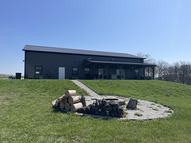 3826 S 77th Rd, Dunnegan, MO 65640 - rear view of property with an outdoor fire pit, a yard, metal roof, and an outbuilding