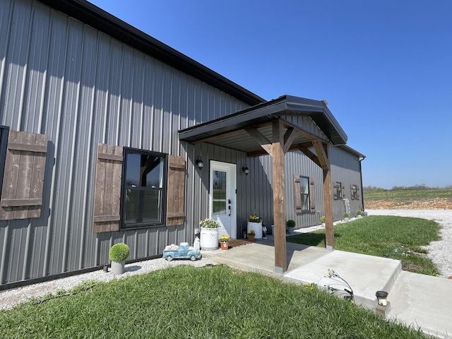 3826 S 77th Rd, Dunnegan, MO 65640 - exterior space featuring board and batten siding, a patio area, and a lawn