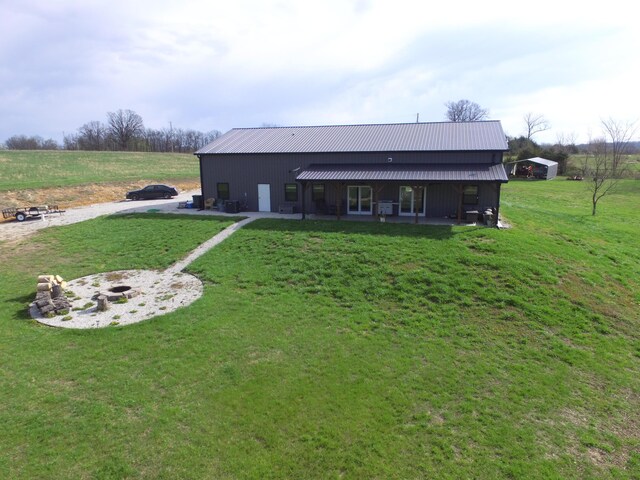 3826 S 77th Rd, Dunnegan, MO 65640 - rear view of house featuring a yard, a fire pit, and metal roof