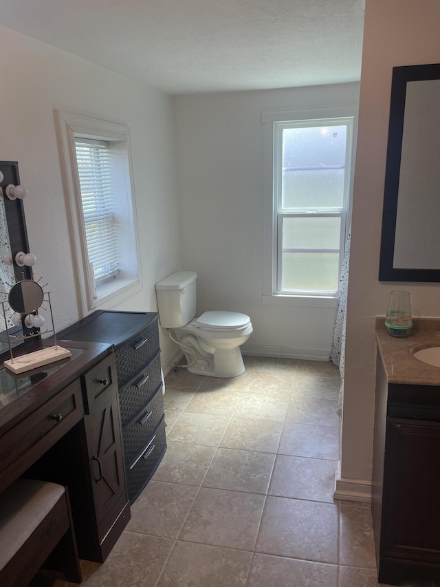 full bathroom with tile patterned floors, toilet, vanity, and baseboards