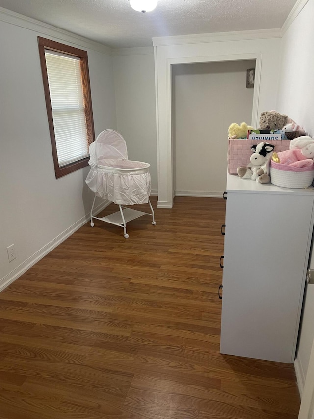 interior space featuring baseboards, crown molding, and wood finished floors