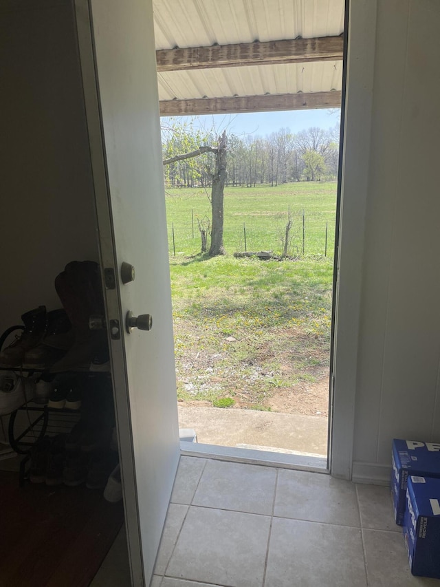 doorway to outside with a rural view, tile patterned flooring, and plenty of natural light