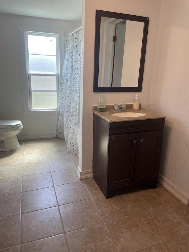 full bathroom with toilet, tile patterned floors, vanity, and baseboards