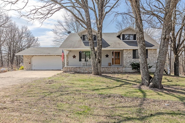 view of front of house with a porch, a garage, driveway, and a front lawn