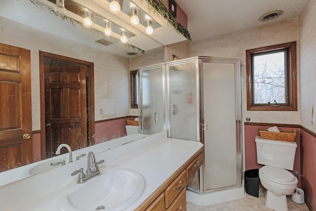 full bath featuring vanity, visible vents, a stall shower, and toilet
