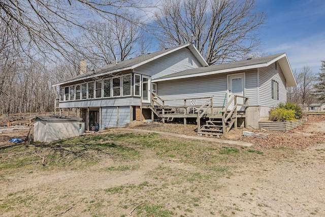 back of property featuring a sunroom, a chimney, and a garage