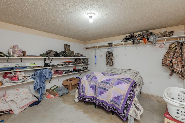 bedroom with a textured ceiling and concrete flooring