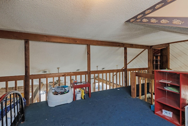 interior space featuring a textured ceiling, wood walls, and carpet floors