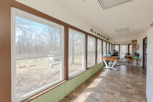 sunroom / solarium with stone finish floor and wood walls