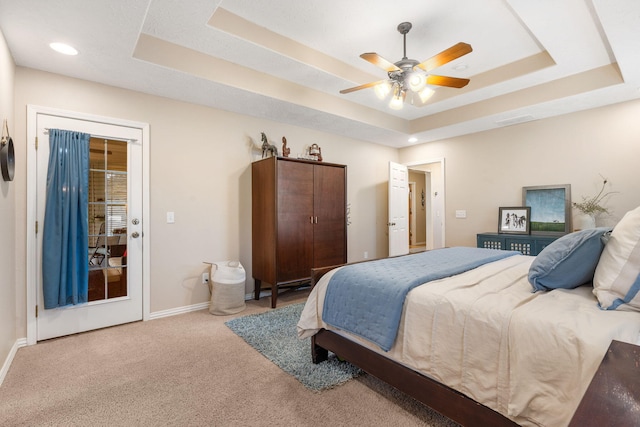 bedroom featuring visible vents, a tray ceiling, baseboards, and carpet floors