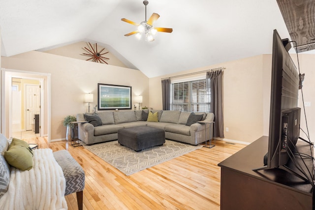 living room with baseboards, light wood finished floors, vaulted ceiling, and a ceiling fan
