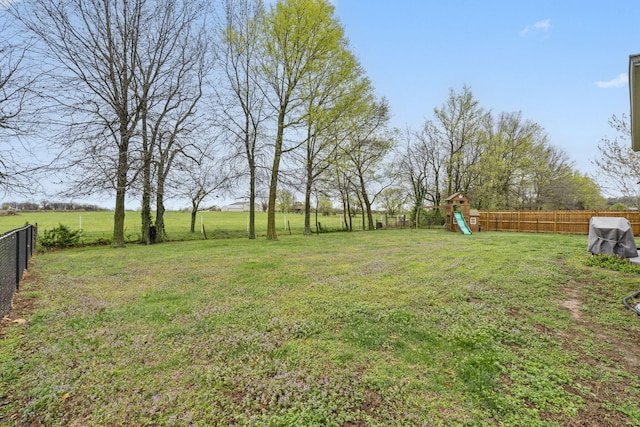 view of yard with a fenced backyard and a playground
