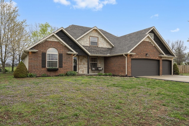 view of front of property with roof with shingles, stone siding, a front lawn, an attached garage, and concrete driveway