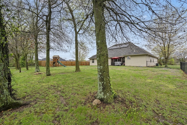view of yard featuring a fenced backyard and a playground
