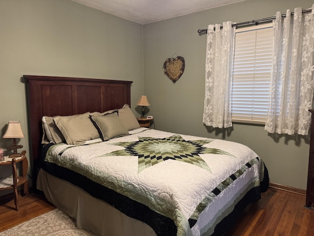 bedroom with wood finished floors and baseboards