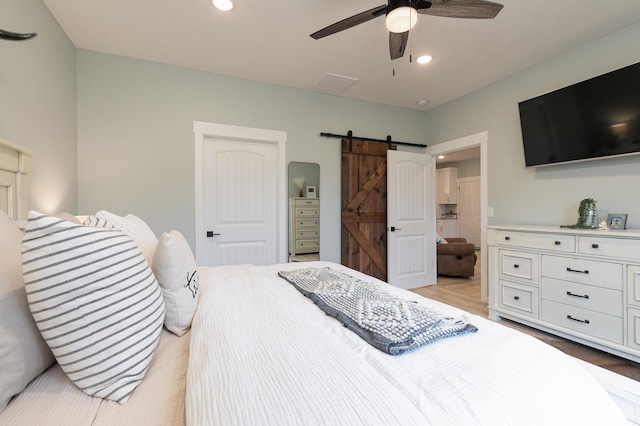 1798 E 328th Rd, Bolivar, MO 65613 - bedroom with light wood-style floors, recessed lighting, a ceiling fan, and a barn door