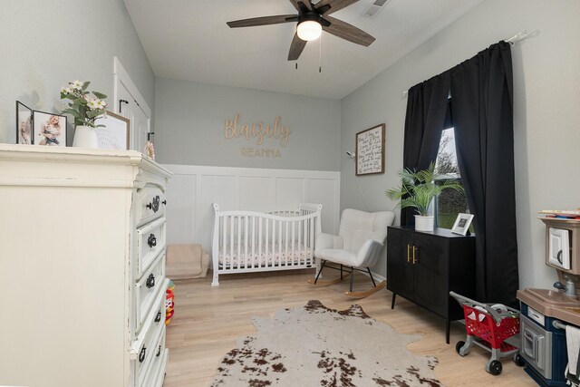 1798 E 328th Rd, Bolivar, MO 65613 - bedroom featuring visible vents, a wainscoted wall, light wood finished floors, and a crib