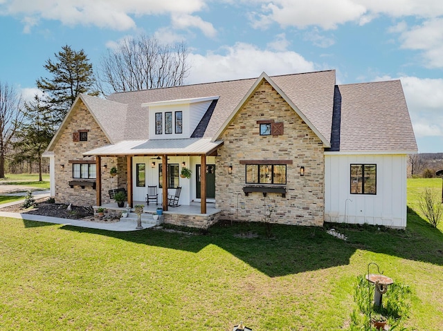 modern farmhouse featuring a porch, board and batten siding, stone siding, and a front lawn