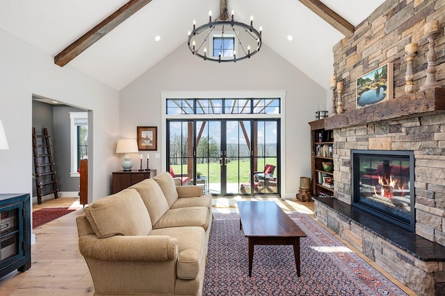 living room featuring a wealth of natural light, an inviting chandelier, beam ceiling, and wood finished floors