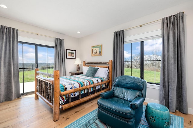 bedroom with recessed lighting, light wood finished floors, access to exterior, and baseboards