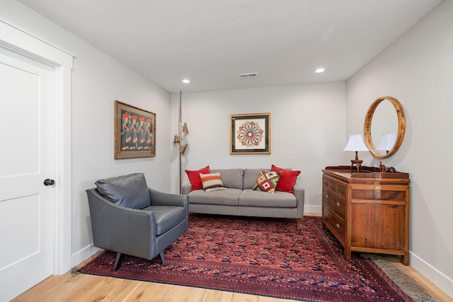 living area featuring visible vents, baseboards, recessed lighting, and wood finished floors