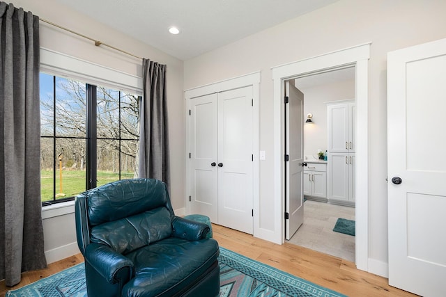 sitting room with light wood-style flooring, recessed lighting, and baseboards