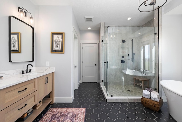 bathroom with visible vents, baseboards, a freestanding tub, vanity, and a stall shower