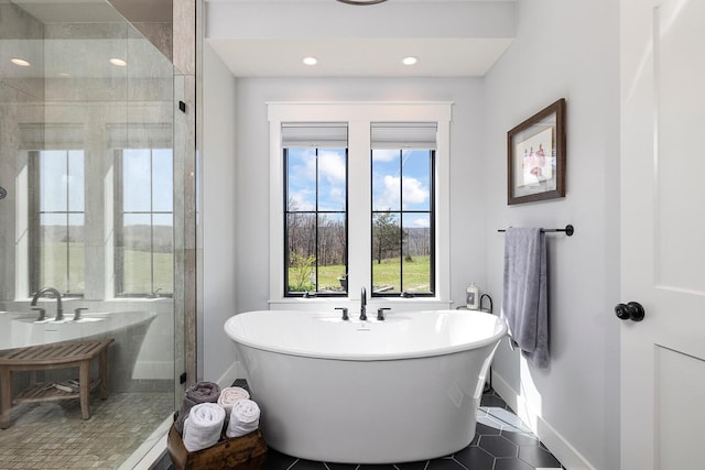 full bath with a shower stall, a freestanding bath, baseboards, and recessed lighting
