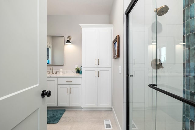 full bath with a shower stall, vanity, and visible vents