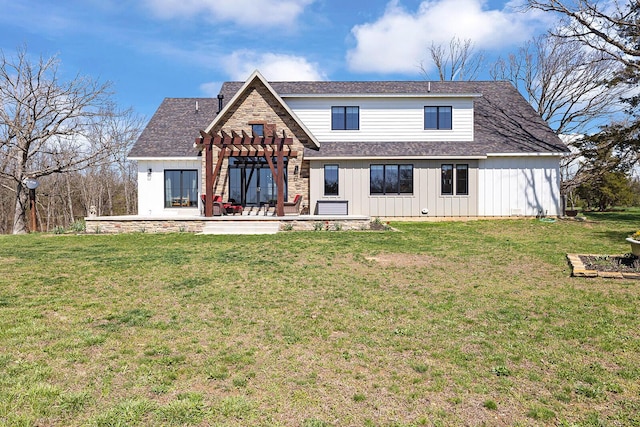 rear view of house featuring a shingled roof, a pergola, a patio area, a yard, and stone siding