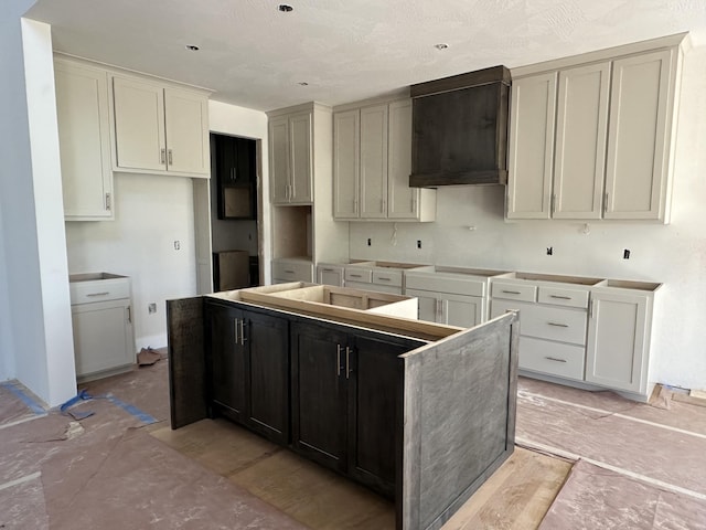 1798 E Cobblestone Dr, Ozark, MO 65721 - kitchen with a kitchen island, custom range hood, and black electric cooktop