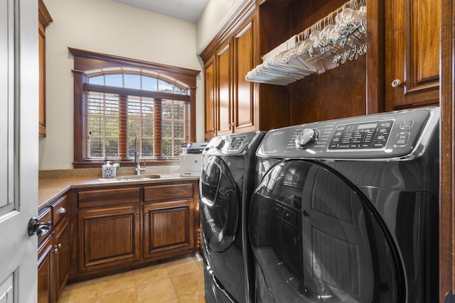 laundry room with a sink, washing machine and clothes dryer, and cabinet space