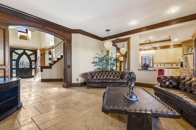 living area featuring crown molding, baseboards, arched walkways, and stone tile floors