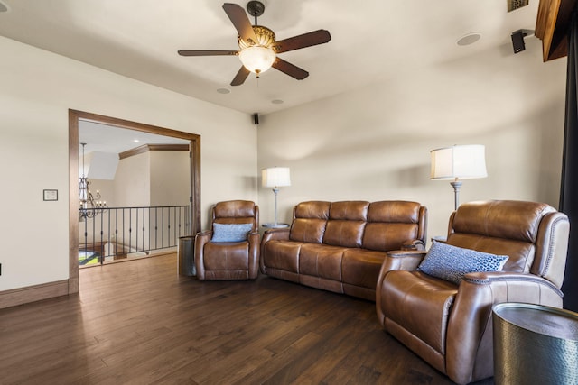 living area featuring dark wood finished floors, baseboards, and ceiling fan