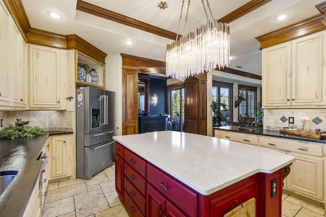 kitchen with a tray ceiling, high quality fridge, recessed lighting, a center island, and stone tile flooring