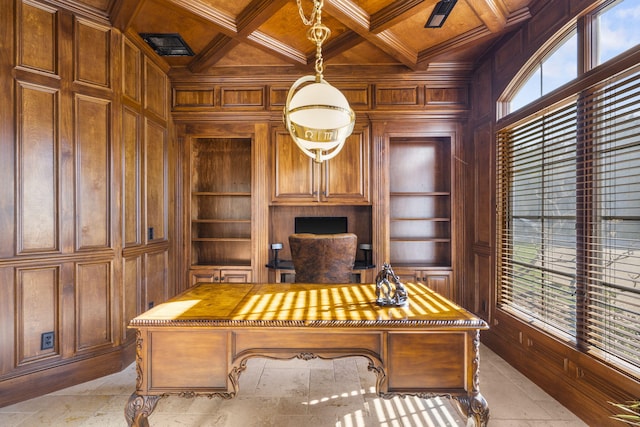 home office featuring coffered ceiling, a healthy amount of sunlight, wood walls, and built in shelves