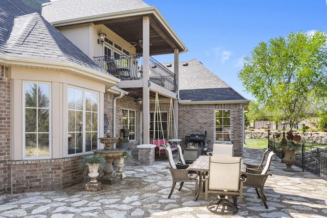 view of patio / terrace with a grill, a ceiling fan, fence, a balcony, and outdoor dining area
