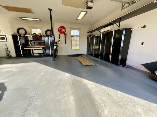 garage with a wall mounted AC, baseboards, and a garage door opener