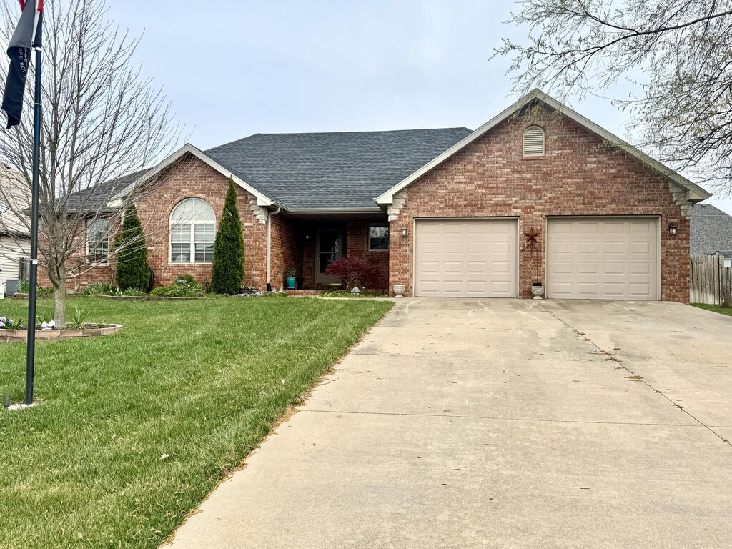 930 Brookside Dr, Marshfield, MO 65706 - ranch-style house featuring a garage, a front yard, brick siding, a shingled roof, and concrete driveway
