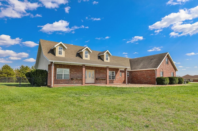view of front of home with a front yard, fence, and brick siding