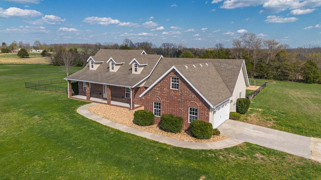 view of front facade featuring brick siding, driveway, fence, and a front lawn