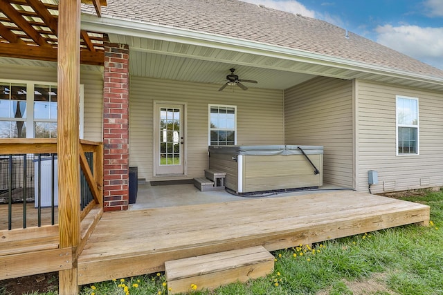 wooden terrace with a ceiling fan and a hot tub
