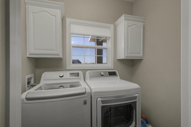 washroom featuring independent washer and dryer and cabinet space