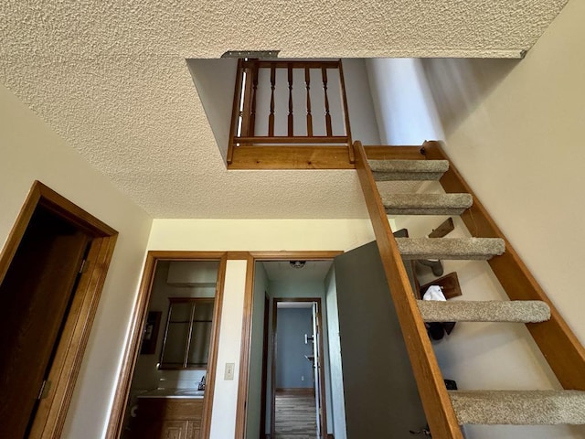 stairway with a textured ceiling