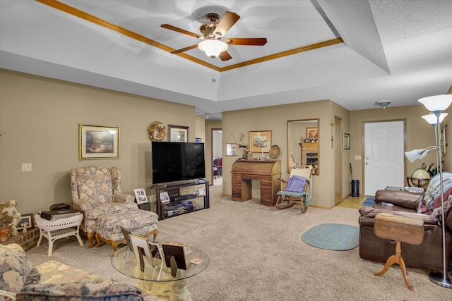 carpeted living room featuring crown molding, a ceiling fan, baseboards, and a raised ceiling