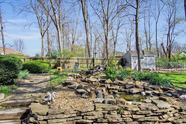 view of yard with a storage shed, an outdoor structure, and a fenced backyard
