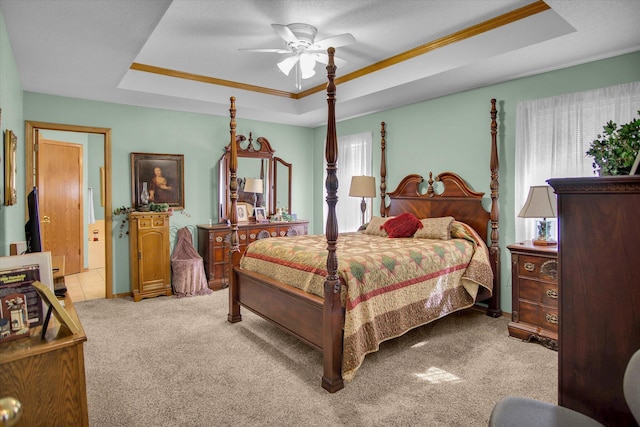 bedroom with ceiling fan, light colored carpet, ornamental molding, and a raised ceiling