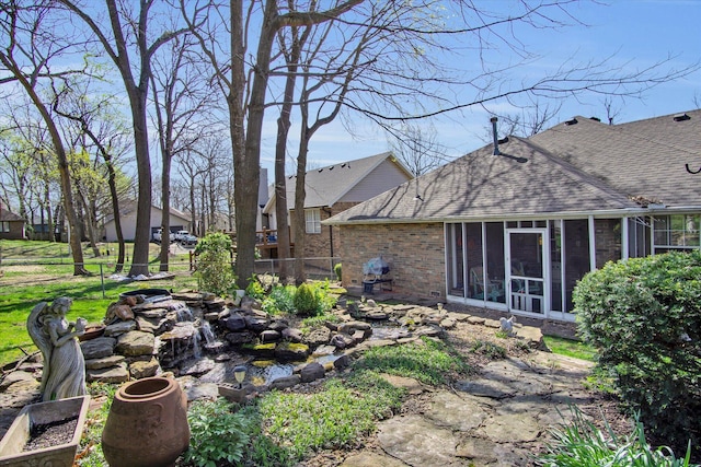 view of yard featuring a sunroom and fence