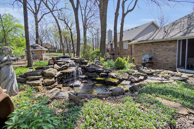 view of yard with a garden pond and fence