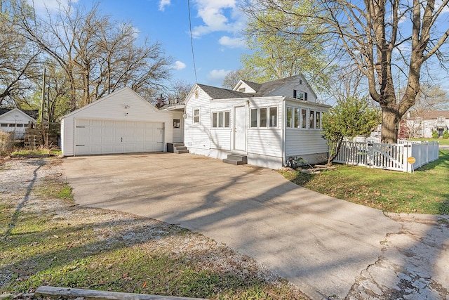 view of front of home with driveway, a front lawn, entry steps, a garage, and fence